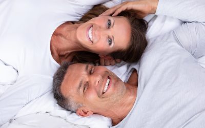 High Angle View Of Happy Mature Couple Lying On Bed